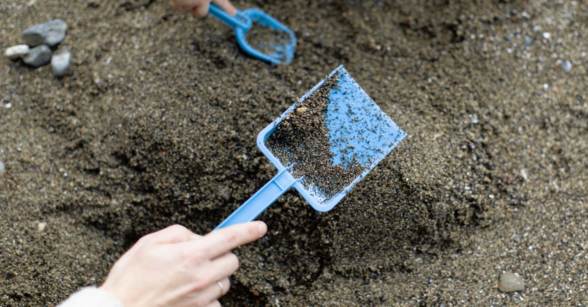 Where can a tourist play horseshoes in Washington, DC? - Crop faceless mother with baby playing with plastic shovels in sand Where can a tourist play horseshoes in Washington, DC? - Crop faceless mother with baby playing with plastic shovels in sand