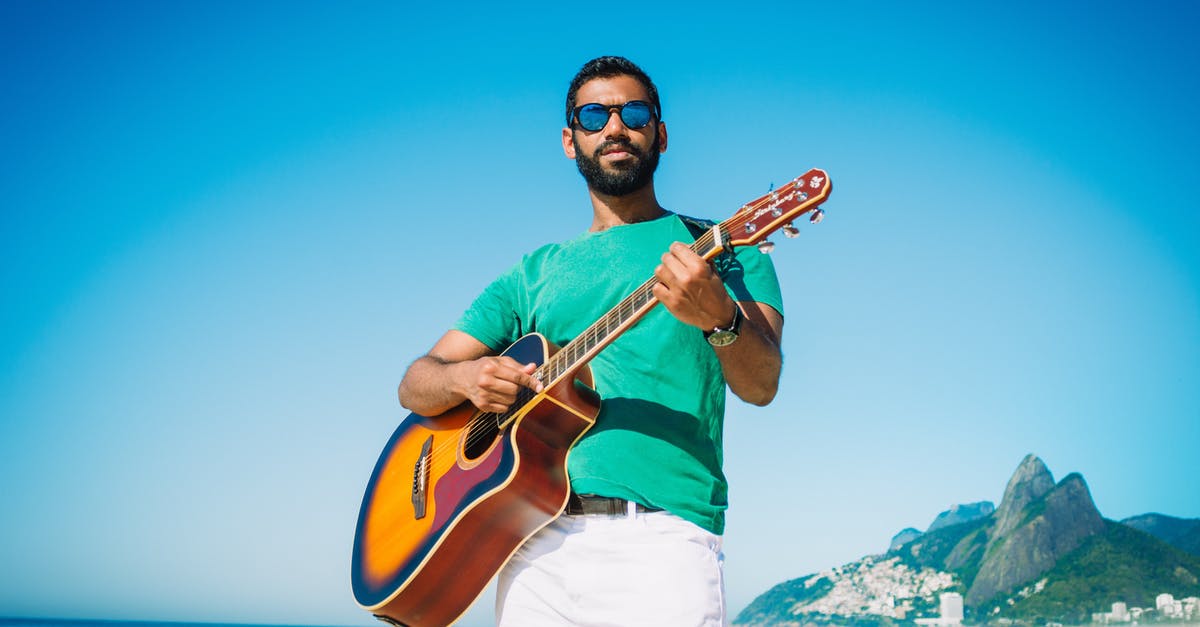 Where can a tourist play horseshoes in Washington, DC? - Low angle of content male in sunglasses playing acoustic guitar while standing on sandy beach near turquoise sea and looking at camera Where can a tourist play horseshoes in Washington, DC? - Low angle of content male in sunglasses playing acoustic guitar while standing on sandy beach near turquoise sea and looking at camera