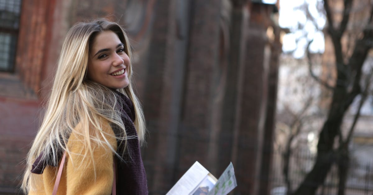 Where can I find a map of paid street parking zones in Munich? - Woman in Brown Coat Holding White Printer Paper