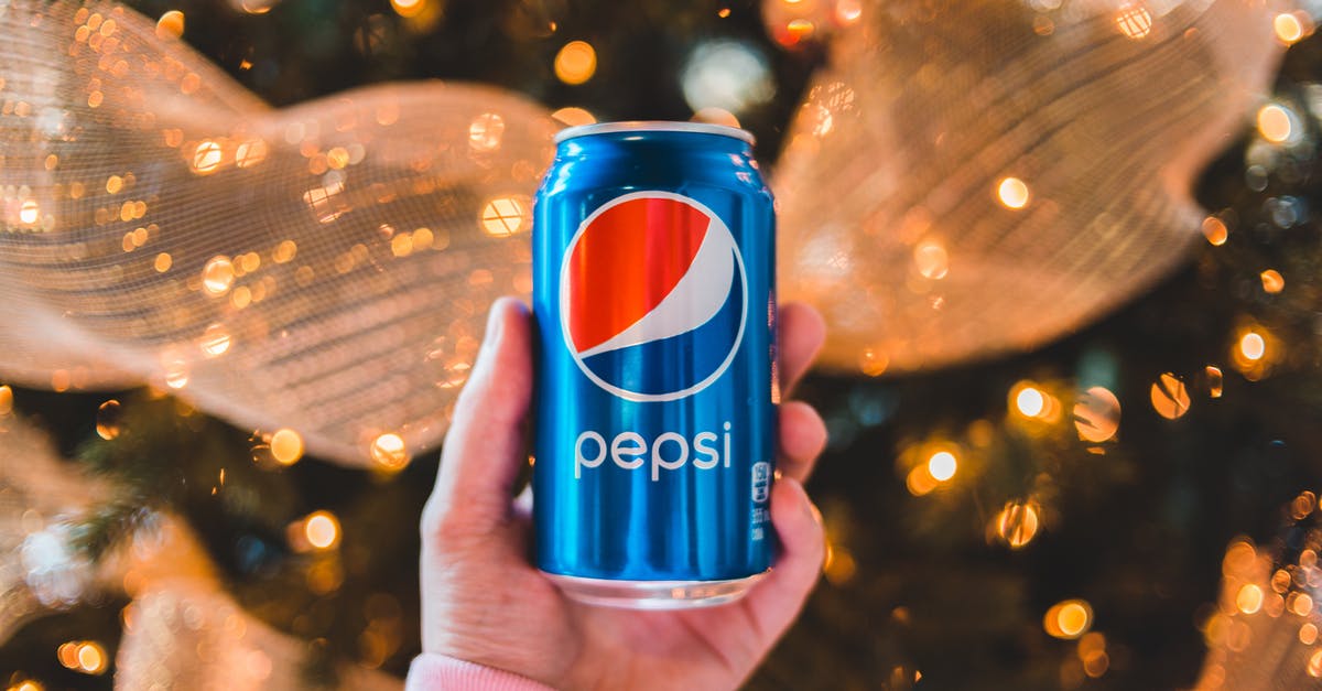 Where can I find event listings for Mumbai? - Crop unrecognizable person showing colorful can of refreshing drink during New Year holiday Where can I find event listings for Mumbai? - Crop unrecognizable person showing colorful can of refreshing drink during New Year holiday