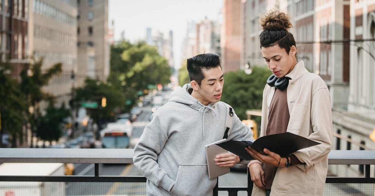 Where can I learn about rules of the road in Europe? [closed] - Diverse smart students reading report on bridge of asphalt road