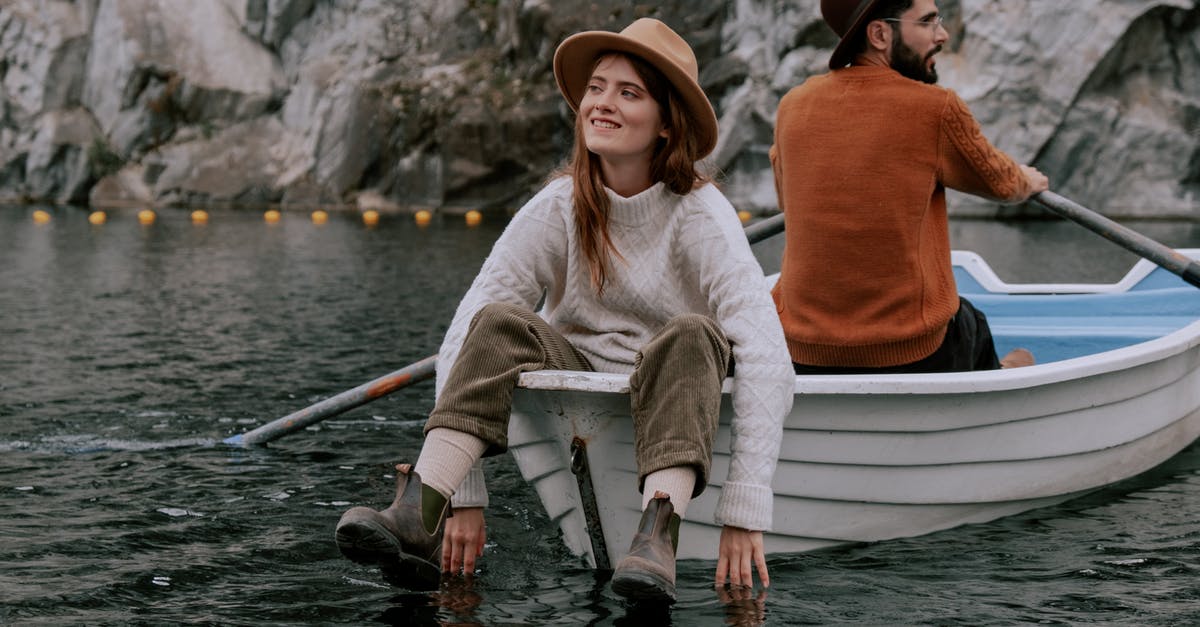 Where can I rent a sailing boat at Orava lake? - A Couple Sitting Back to Back while Riding a Boat Where can I rent a sailing boat at Orava lake? - A Couple Sitting Back to Back while Riding a Boat