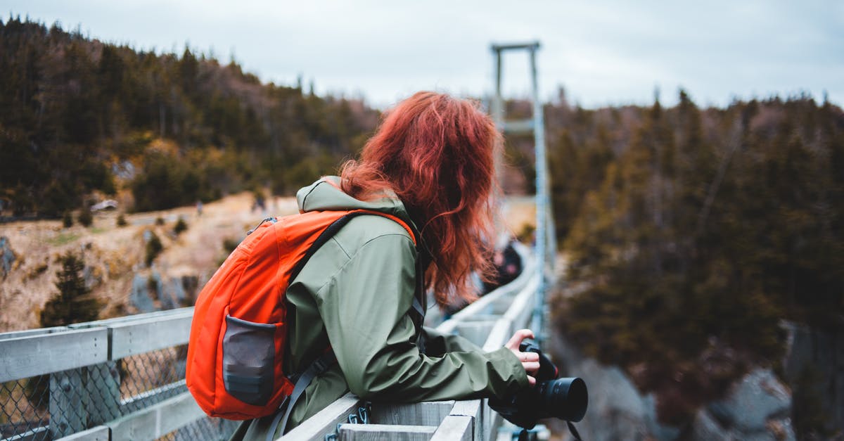 Where can I visit the mussel grow locations in Rías Baixas, Galicia, Spain? - Anonymous woman with backpack and photo camera standing on bridge Where can I visit the mussel grow locations in Rías Baixas, Galicia, Spain? - Anonymous woman with backpack and photo camera standing on bridge