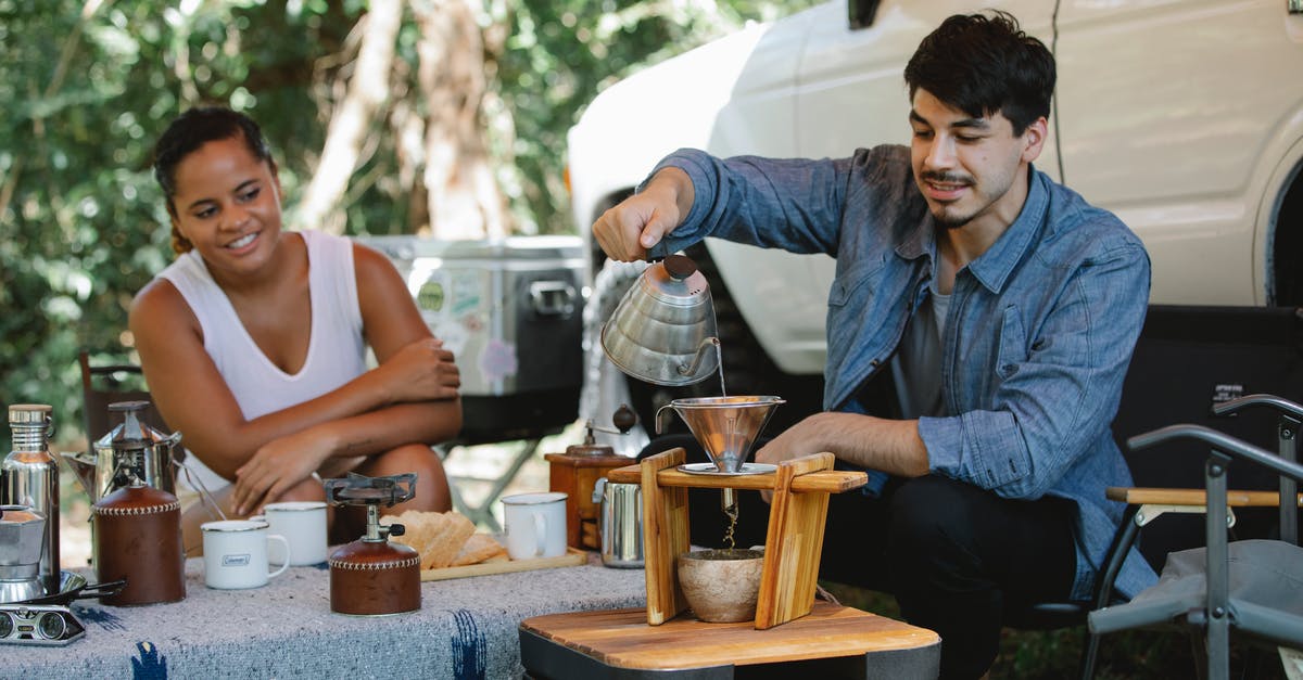 Where can you buy a portable Distiller or a Reverse Osmosis water filter in London? [closed] - Happy diverse couple preparing pour over coffee in campsite