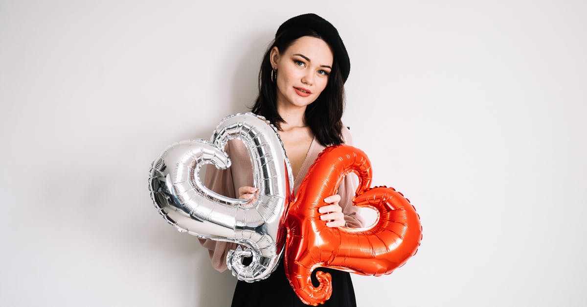 Where can you rent Tesla S or X model in Frankfurt? - Woman in Black and White Clothes Holding Heart Shaped Balloon