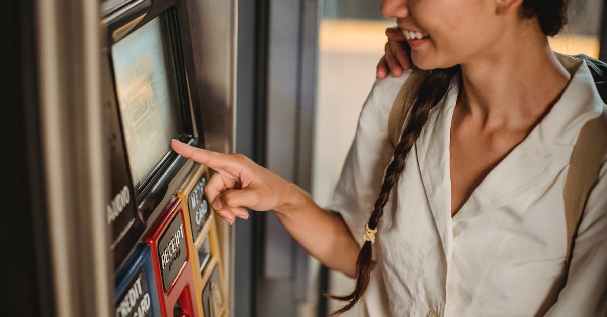 Where in LGA Terminal B can one buy a Metro Card? - Crop smiling Asian female in white shirt using ticket vending machine with touch screen in underground Where in LGA Terminal B can one buy a Metro Card? - Crop smiling Asian female in white shirt using ticket vending machine with touch screen in underground