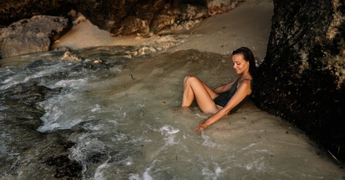 Where is a good/interesting place to go outside of (but not too far) from Osaka? Looking for an overnight trip [closed] - Positive woman in swimsuit leaning on mountain slope in water