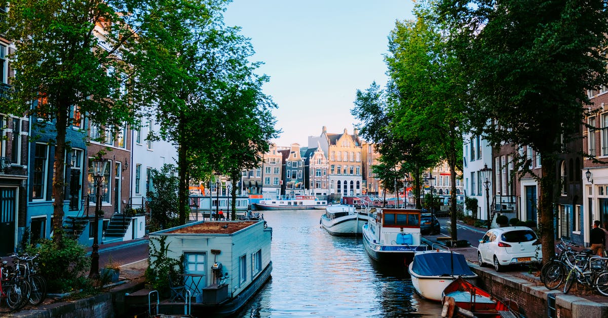Where is a hipster/"bobo" neighborhood in Amsterdam? - Peaceful scenery of Amsterdam streets with typical houses against channel with moored boats on clear sunny day Where is a hipster/"bobo" neighborhood in Amsterdam? - Peaceful scenery of Amsterdam streets with typical houses against channel with moored boats on clear sunny day