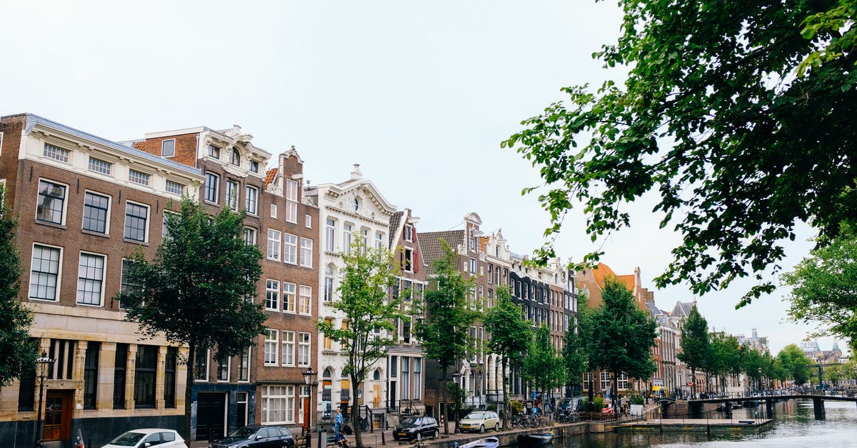 Where is a hipster/"bobo" neighborhood in Amsterdam? - Typical Dutch architecture of cozy buildings situated on riverbank during clear spring day Where is a hipster/"bobo" neighborhood in Amsterdam? - Typical Dutch architecture of cozy buildings situated on riverbank during clear spring day