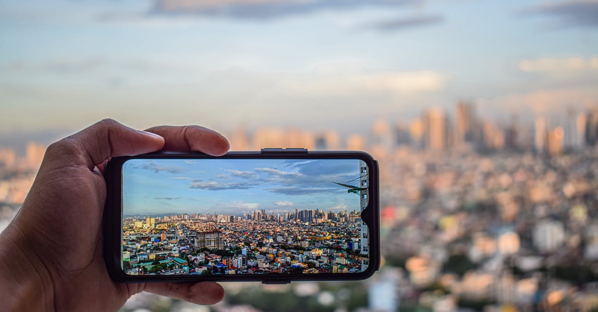Where is the cityscape in this recent photo, probably in Malaysia? - Hand Taking Photo of City Where is the cityscape in this recent photo, probably in Malaysia? - Hand Taking Photo of City
