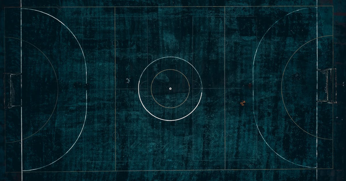 Where is the safest place in a train? - Drone top view of outdoors football field with dark blue surface located in suburb in daylight Where is the safest place in a train? - Drone top view of outdoors football field with dark blue surface located in suburb in daylight