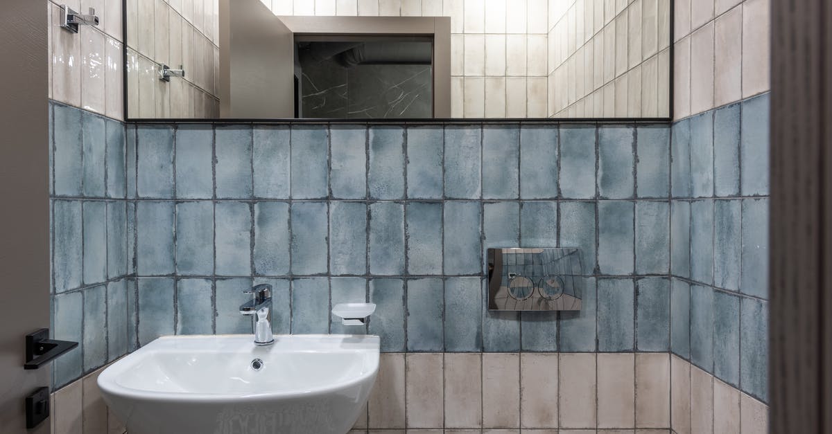 Where is this blue tile in the New York subway? - Interior of modern restroom with ceramic white sink and mirror hanging on white and blue tiled wall Where is this blue tile in the New York subway? - Interior of modern restroom with ceramic white sink and mirror hanging on white and blue tiled wall
