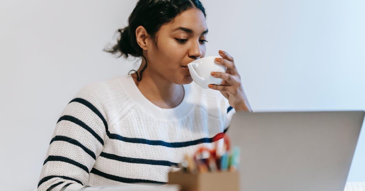 Where to book Indian train tickets online? - Ethnic lady working remotely on laptop with cup of drink Where to book Indian train tickets online? - Ethnic lady working remotely on laptop with cup of drink