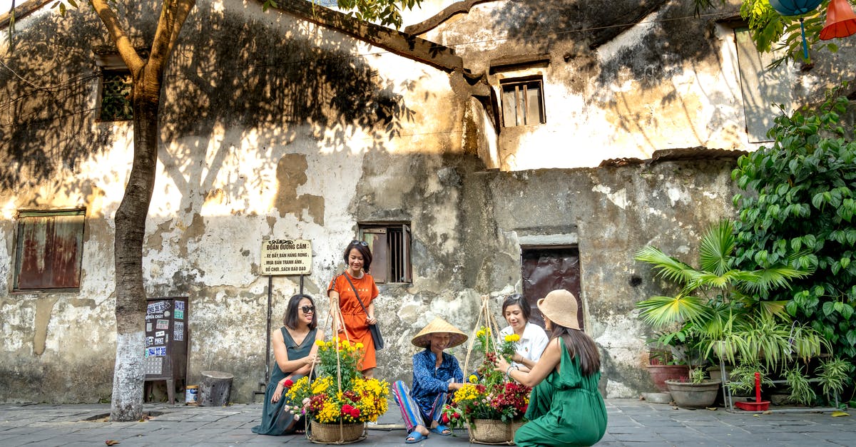 Where to buy a similar Vietnam SIM card aimed for locals/expats (not for tourists) in HCMC? [duplicate] - Positive ethnic women buying flowers from local female seller in countryside