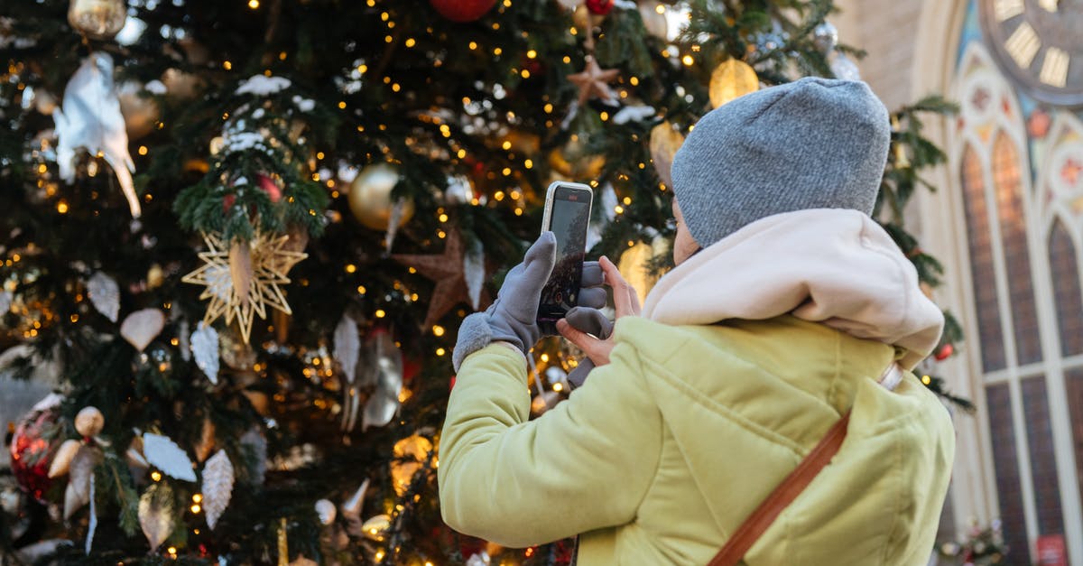 Where to buy winter clothes in Rome , Italy? [closed] - Unrecognizable Female Person in Winter Clothes Making Photo of Decorated Christmas Tree