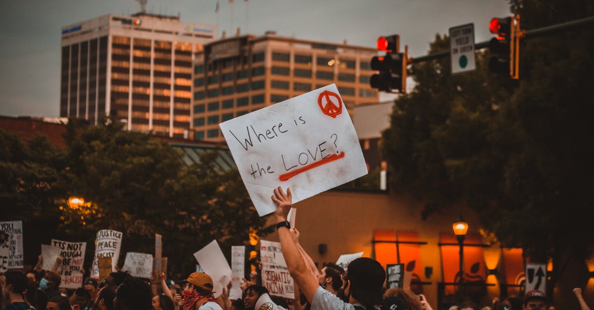 Where to stay under movement restrictions in Ireland? - Multiracial people with banners protesting on street in evening Where to stay under movement restrictions in Ireland? - Multiracial people with banners protesting on street in evening