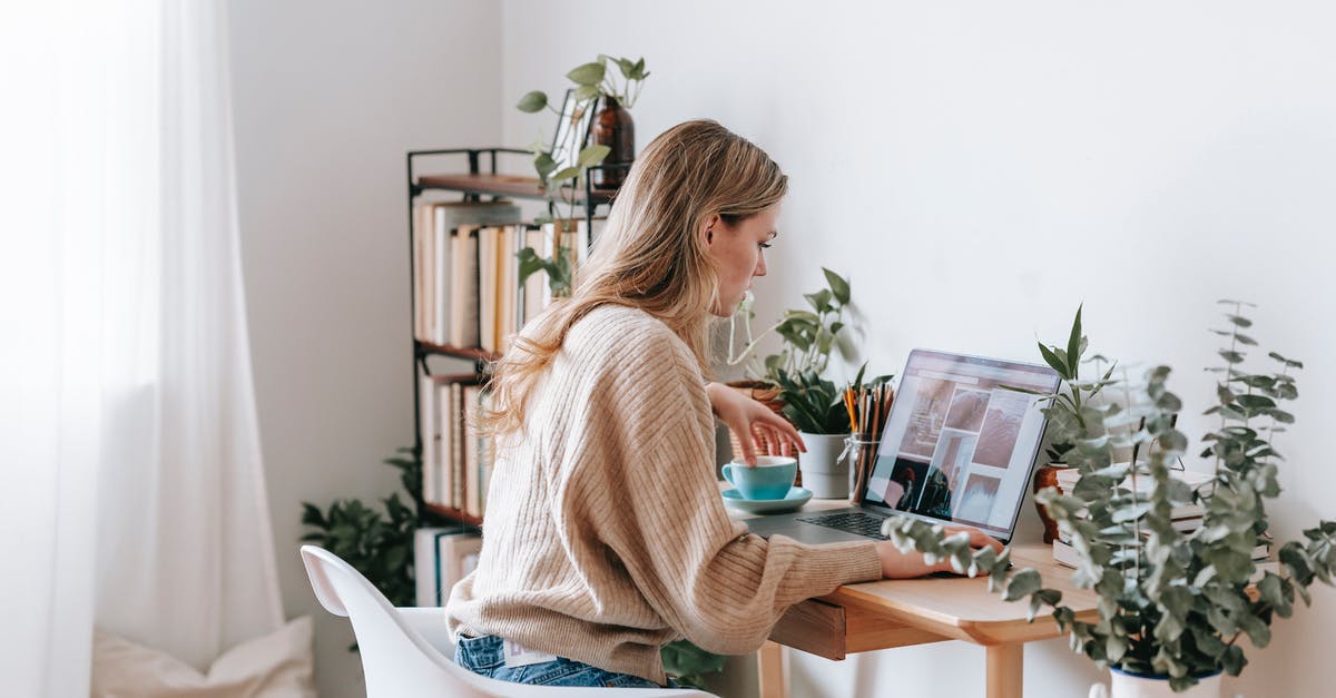 Where was this photo taken? Windows 10 photo lock screen [duplicate] - Side view of attentive female remote employee with cup of tea watching photo gallery on netbook screen at desk in house