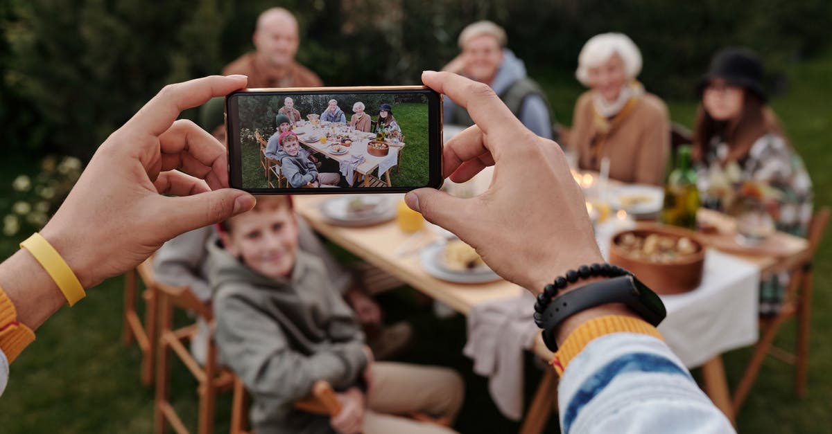 Where was this photo taken? Windows 10 photo lock screen [duplicate] - Unrecognizable person taking photo of family dinner on smartphone