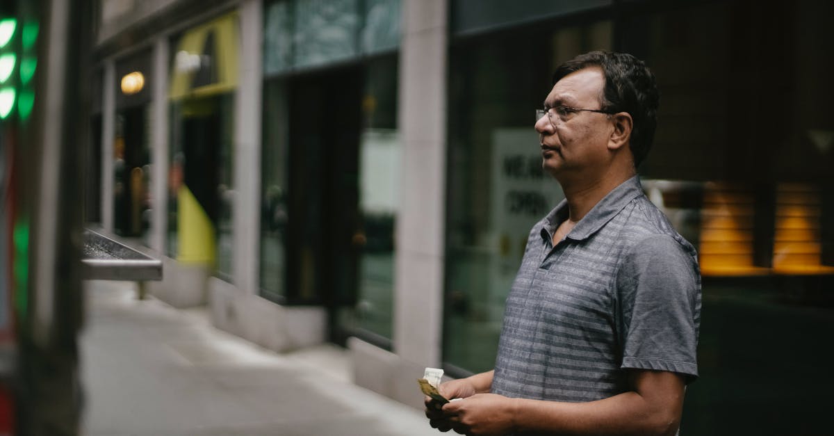 Which ATMs offer no-fee cash withdrawals in Chile? - Serious ethnic man standing with money on street Which ATMs offer no-fee cash withdrawals in Chile? - Serious ethnic man standing with money on street