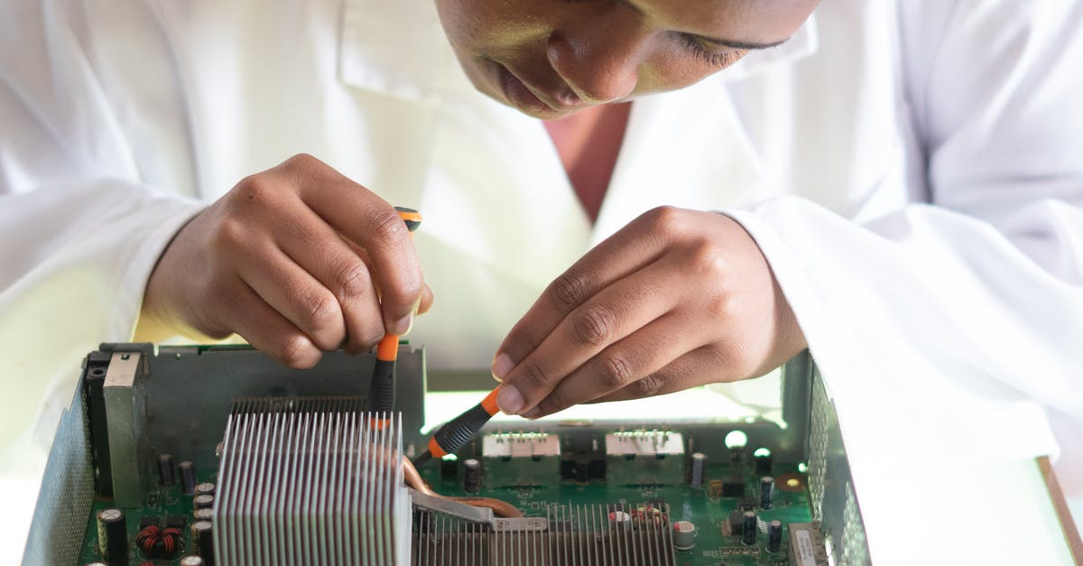 Which frequent flyer card to use? - Concentrated African American technician wearing lab coat and conducting expertise of motherboard by using screwdrivers while working in service center Which frequent flyer card to use? - Concentrated African American technician wearing lab coat and conducting expertise of motherboard by using screwdrivers while working in service center