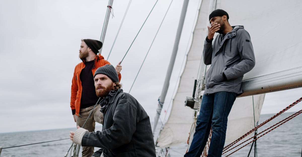 Which is the lowest budget for a trip to Indonesian Papua? - Man in Black Jacket and Orange Knit Cap Standing Beside Man in Black Jacket Which is the lowest budget for a trip to Indonesian Papua? - Man in Black Jacket and Orange Knit Cap Standing Beside Man in Black Jacket