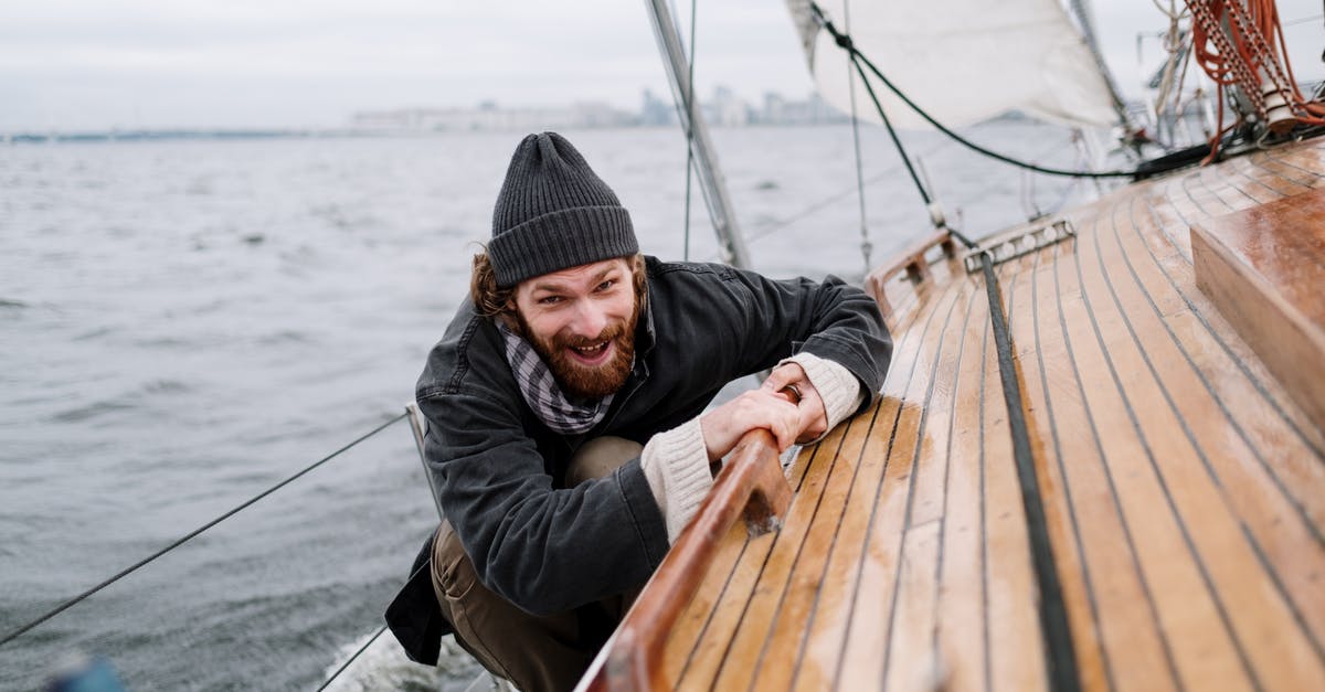 Which is the lowest budget for a trip to Indonesian Papua? - Man in Black Jacket Sitting on Brown Wooden Boat Which is the lowest budget for a trip to Indonesian Papua? - Man in Black Jacket Sitting on Brown Wooden Boat