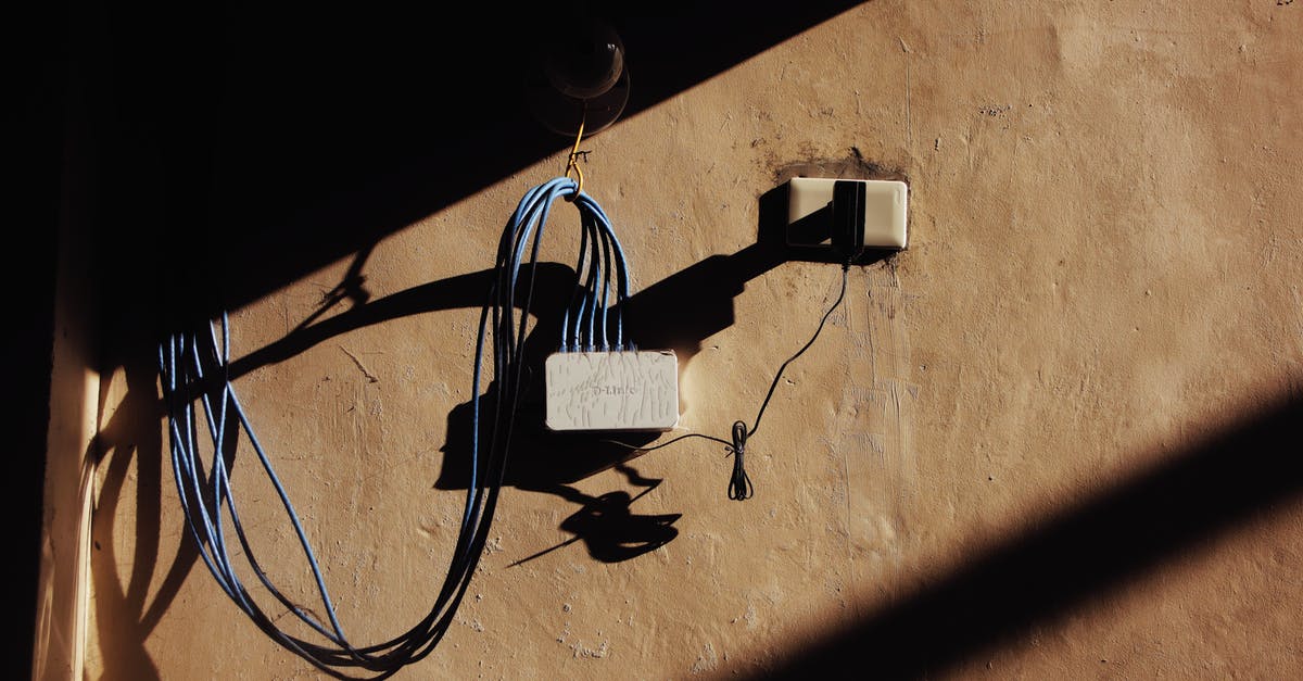 Which kind of appliances can one connect to electric sockets located in an airplane's toilet? - Electric blue wires connected to network adapter plugged in socket on shabby brown wall of building on street with shadow Which kind of appliances can one connect to electric sockets located in an airplane's toilet? - Electric blue wires connected to network adapter plugged in socket on shabby brown wall of building on street with shadow