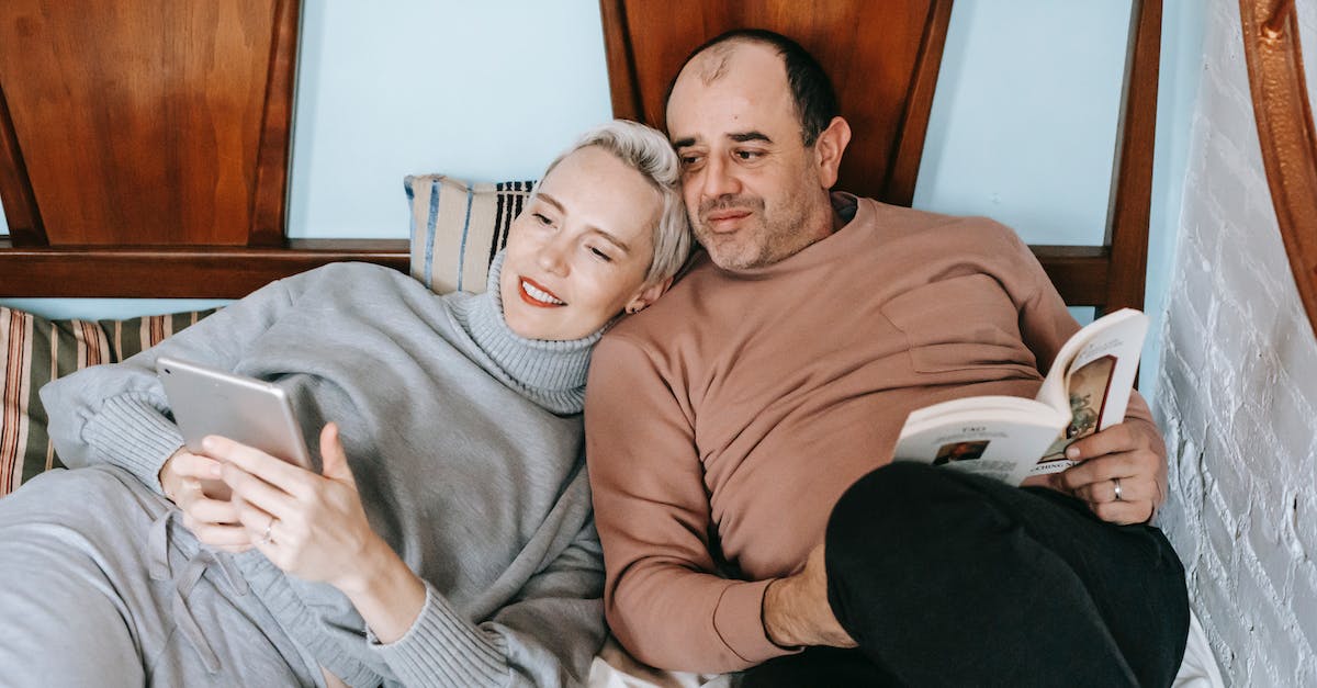 Which of these airports is the most interesting for a pilot? [closed] - High angle of happy adult woman using tablet and cuddling with ethnic husband reading interesting book on bed at home
