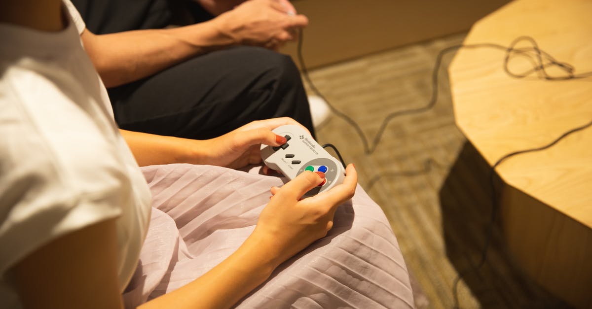 Which queue for an unmarried EU/non-EU couple travelling through UK Immigration Control together? - Unrecognizable couple playing video game with gamepads at home
