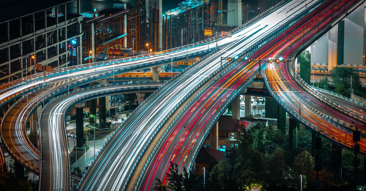 Which route to take driving from Seattle to Boston? - From above long exposure traffic on modern highway elevated above ground level surrounded by urban constructions in evening Which route to take driving from Seattle to Boston? - From above long exposure traffic on modern highway elevated above ground level surrounded by urban constructions in evening
