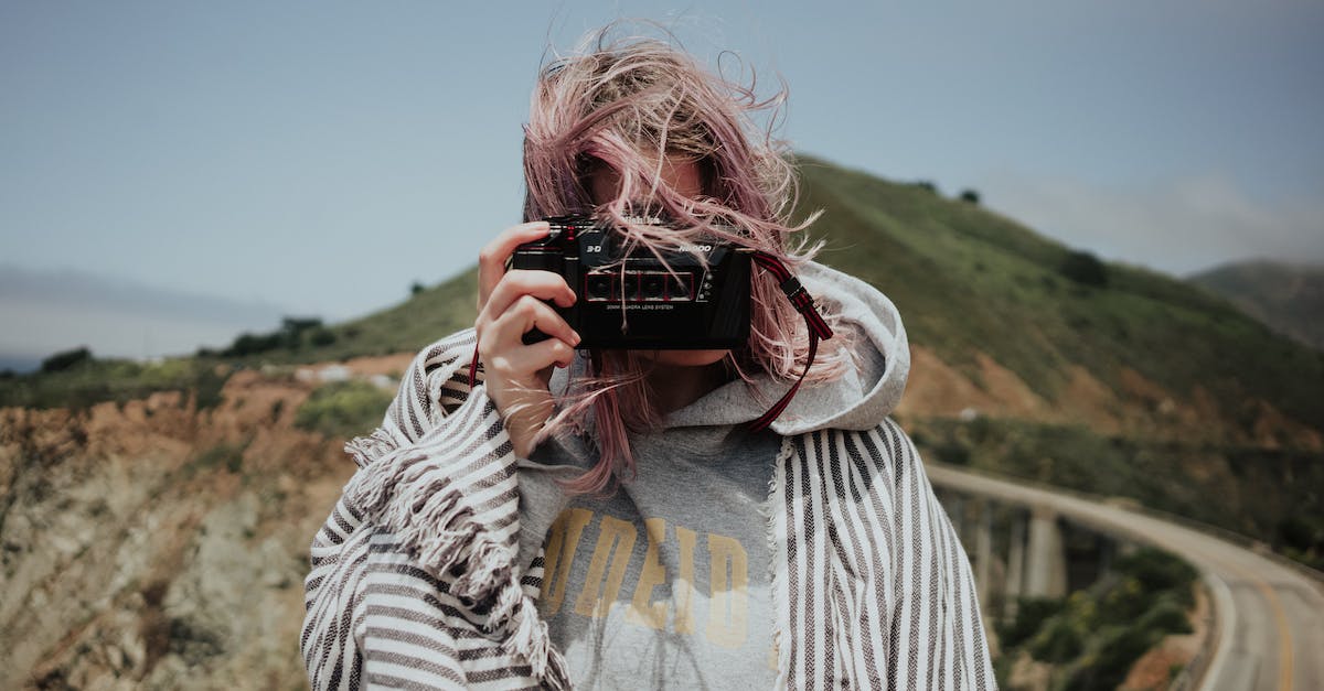 Which scenic road to take to the south of France? - Woman in plaid taking photo in mountains Which scenic road to take to the south of France? - Woman in plaid taking photo in mountains
