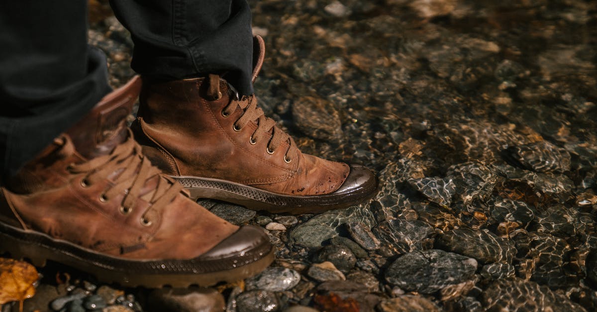 Which trekking shoes to get for trekking in Costa Rica - Crop unrecognizable person in autumn boots and black jeans standing near water in forest Which trekking shoes to get for trekking in Costa Rica - Crop unrecognizable person in autumn boots and black jeans standing near water in forest