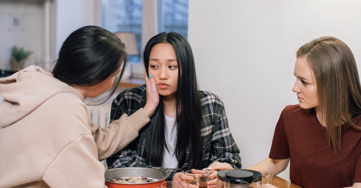 Which types of accommodations are affected by Lisbon's municipal tax? - Woman in White Long Sleeve Shirt Sitting Beside Woman in Black and White Plaid Shirt