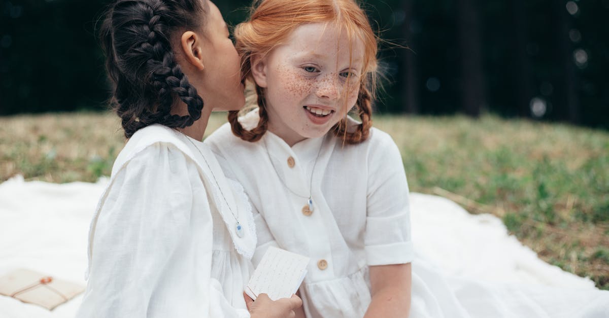 Whispering in other cultures - Girl Whispering to Ear of Friend Whispering in other cultures - Girl Whispering to Ear of Friend
