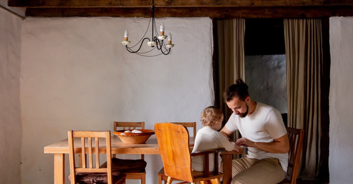White House tours on weekends? - Focused young man with toddler girl sitting at desk in rural interior house White House tours on weekends? - Focused young man with toddler girl sitting at desk in rural interior house