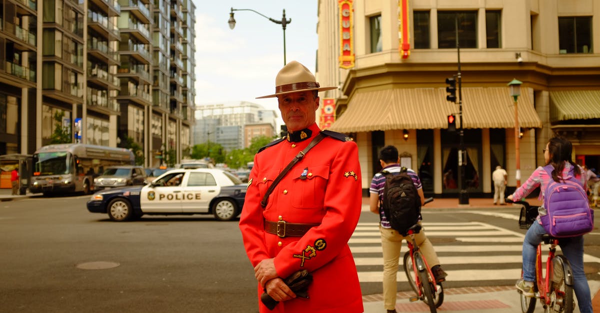 Who goes first? Person disembarking bus or the bicycle? - Man in Uniform Standing on Sidewalk Who goes first? Person disembarking bus or the bicycle? - Man in Uniform Standing on Sidewalk