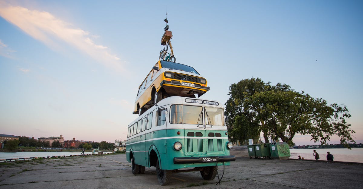Who goes first? Person disembarking bus or the bicycle? - Teal Bus With Yellow Car on Roof Who goes first? Person disembarking bus or the bicycle? - Teal Bus With Yellow Car on Roof