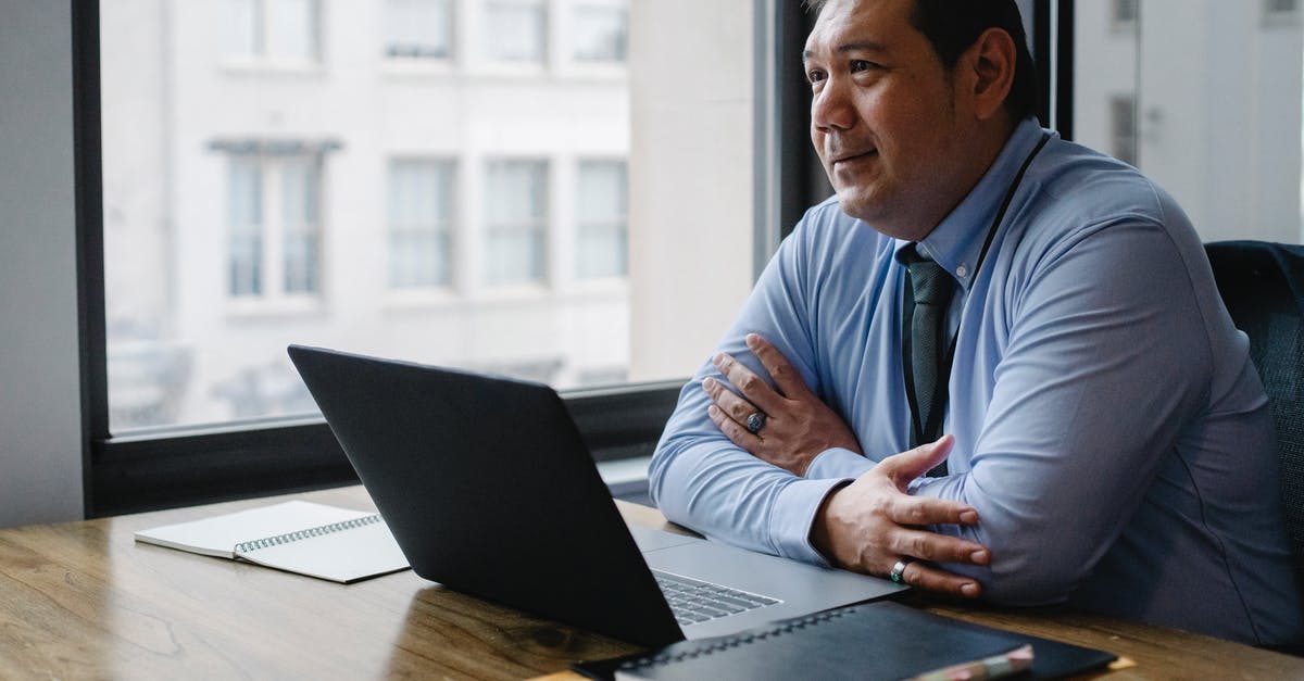 Who is officially responsible for rebooking a missed connection? - Adult successful ethnic male boss wearing shirt and tie sitting with hands crossed at workplace with documents and netbook Who is officially responsible for rebooking a missed connection? - Adult successful ethnic male boss wearing shirt and tie sitting with hands crossed at workplace with documents and netbook