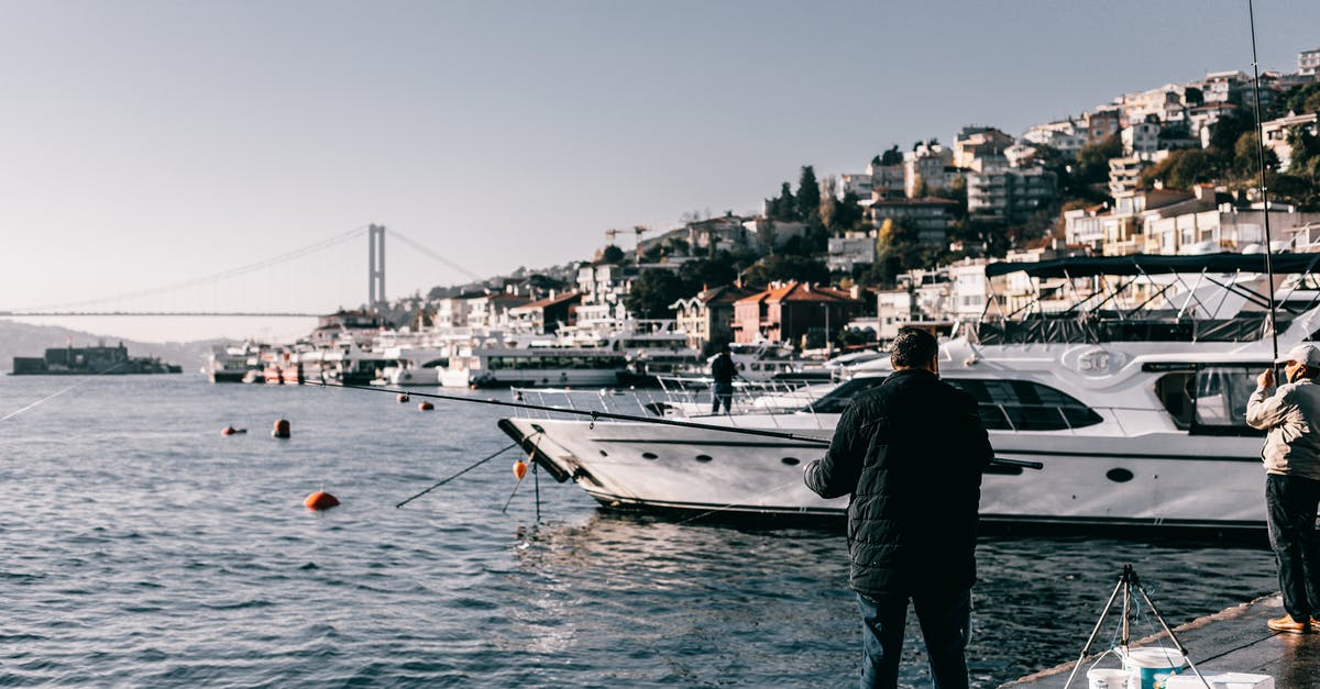 Why are plane tickets more expensive if they don't include a weekend? - People catching fish with rods on shoreline with yachts Why are plane tickets more expensive if they don't include a weekend? - People catching fish with rods on shoreline with yachts