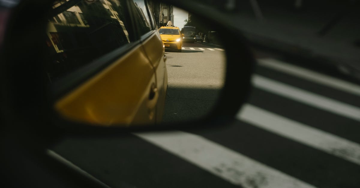 Why are there yellow dot stickers on the front doors of businesses in Russia? - Modern taxi cars driving on road with crosswalk Why are there yellow dot stickers on the front doors of businesses in Russia? - Modern taxi cars driving on road with crosswalk