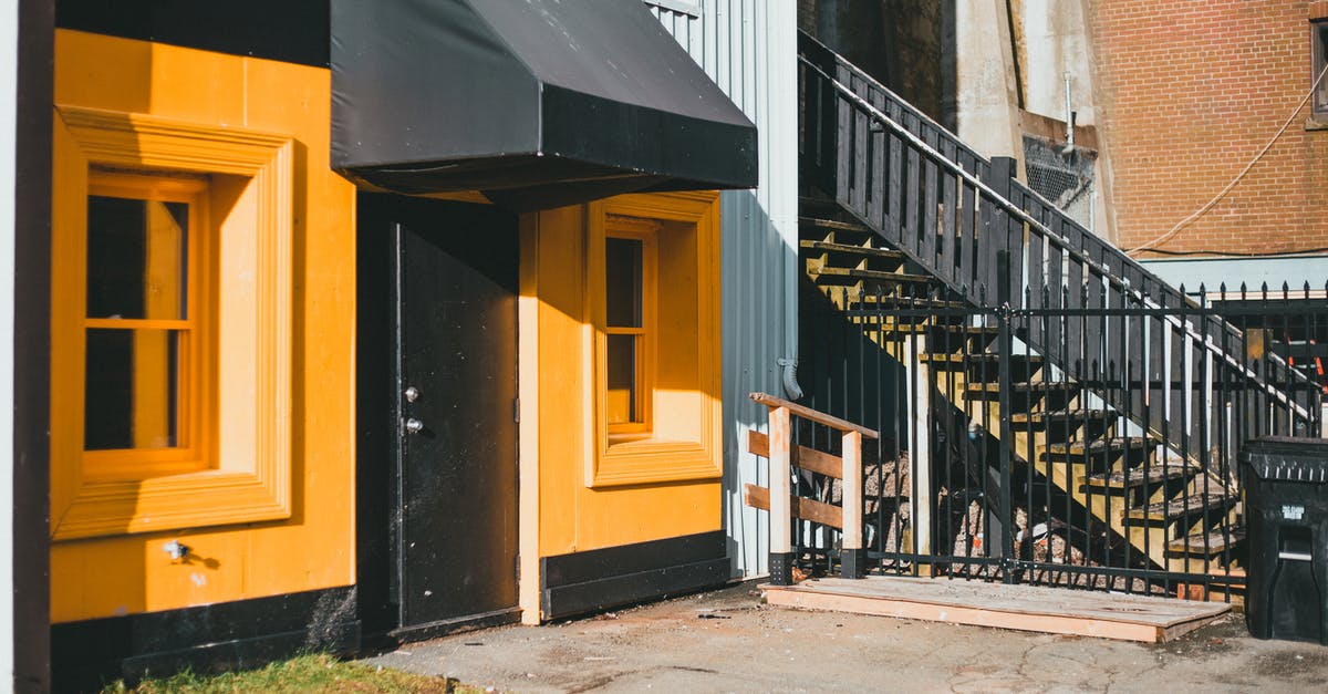 Why are there yellow dot stickers on the front doors of businesses in Russia? - Modern house facade with canopy against stairs in town Why are there yellow dot stickers on the front doors of businesses in Russia? - Modern house facade with canopy against stairs in town