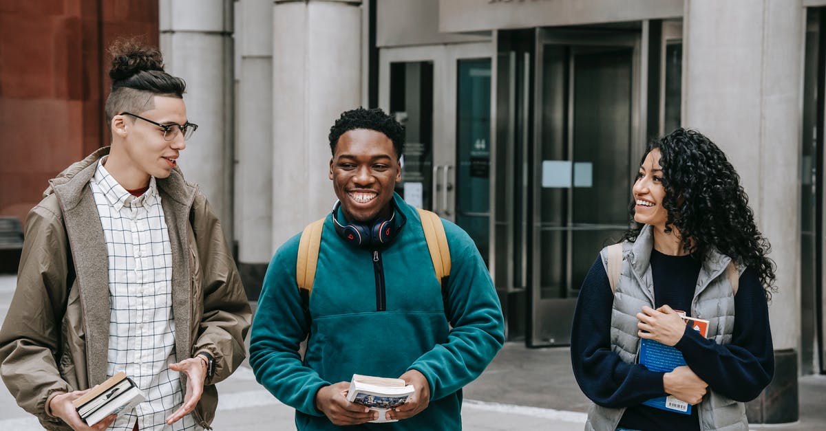 Why can't I book this multi-city fare on American Airlines? - Group of smiling multiracial students with books strolling near building Why can't I book this multi-city fare on American Airlines? - Group of smiling multiracial students with books strolling near building