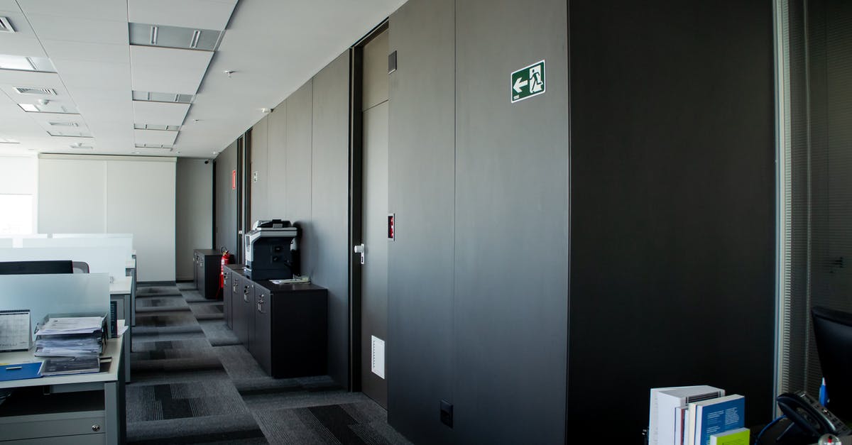 Why did a gate officer and exit immigration officer try to peel my visa sticker? - Modern workplace interior with tables and carpeting floor