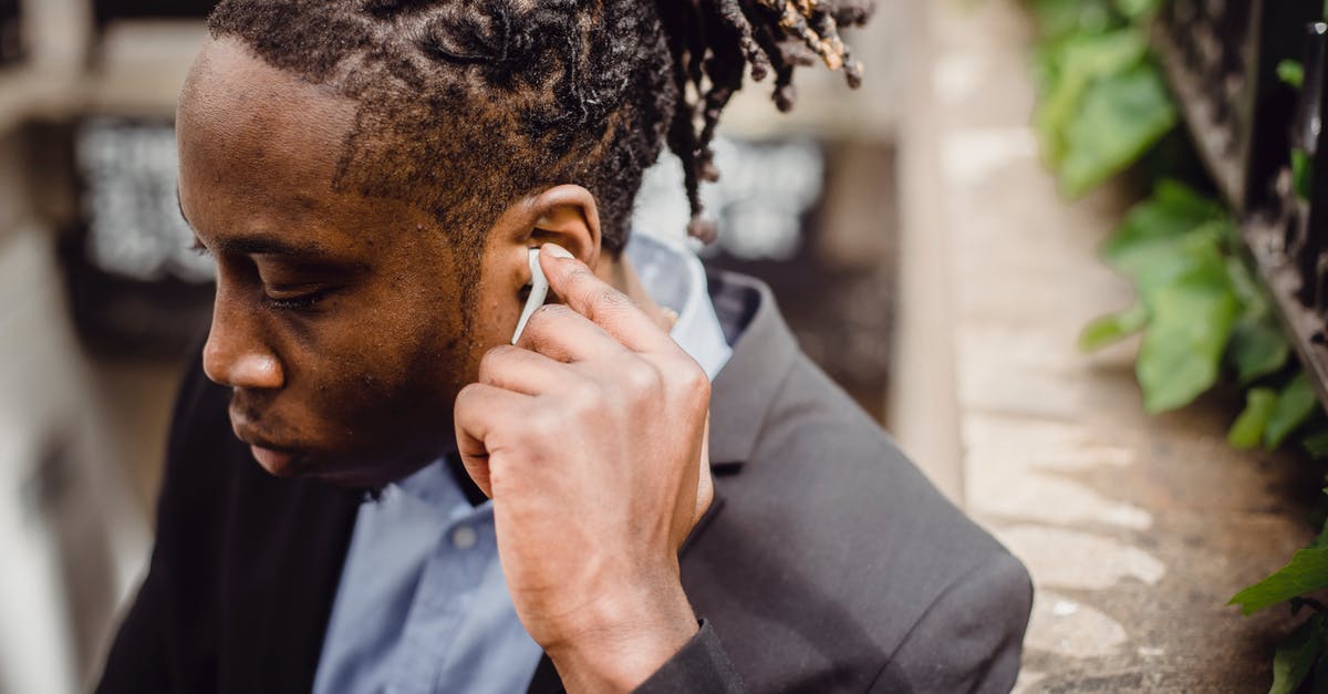 Why did an immigration office left his booth for a while while processing my exit from Schengen area? [closed] - Young black male in suit listening to music on street