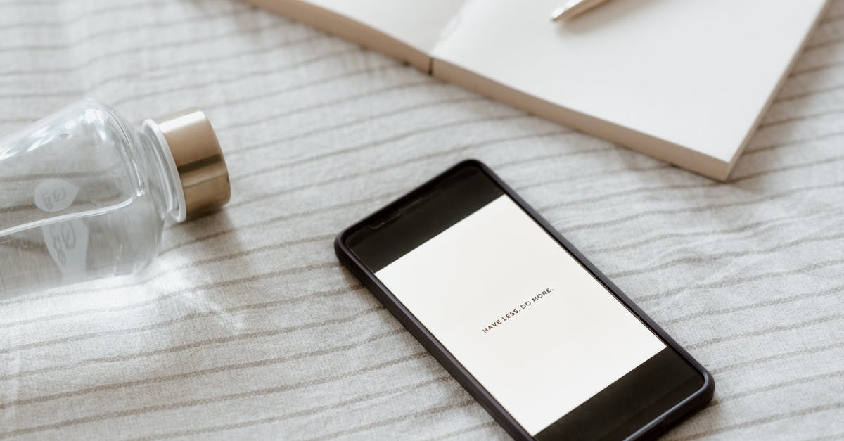 Why do airline tickets have titles in addition to names? - From above of cellphone with Have Less Do More inscription on screen near empty notebook and bottle of water