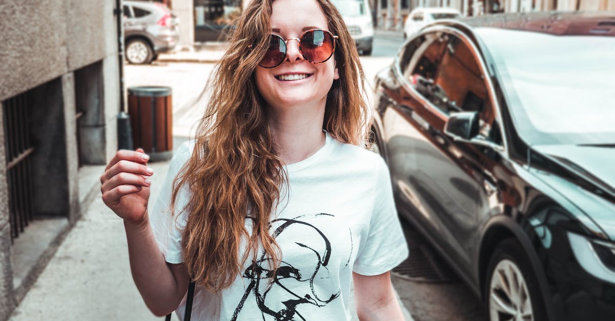 Why do cable cars (gondola lifts) only have doors on one side? [closed] - Photo of Smiling Woman in White T-shirt and Sunglasses Walking on Side Walk