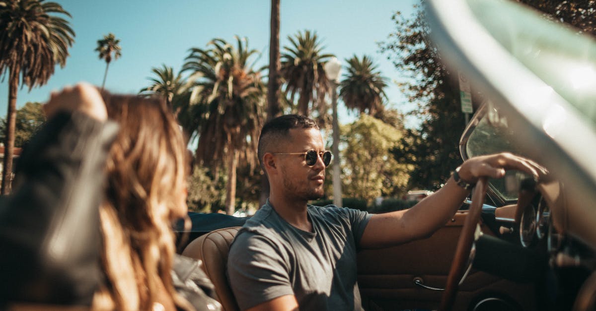 Why do rental car companies hand you two keys wired together? - Man and Woman Riding Convertible Car Why do rental car companies hand you two keys wired together? - Man and Woman Riding Convertible Car