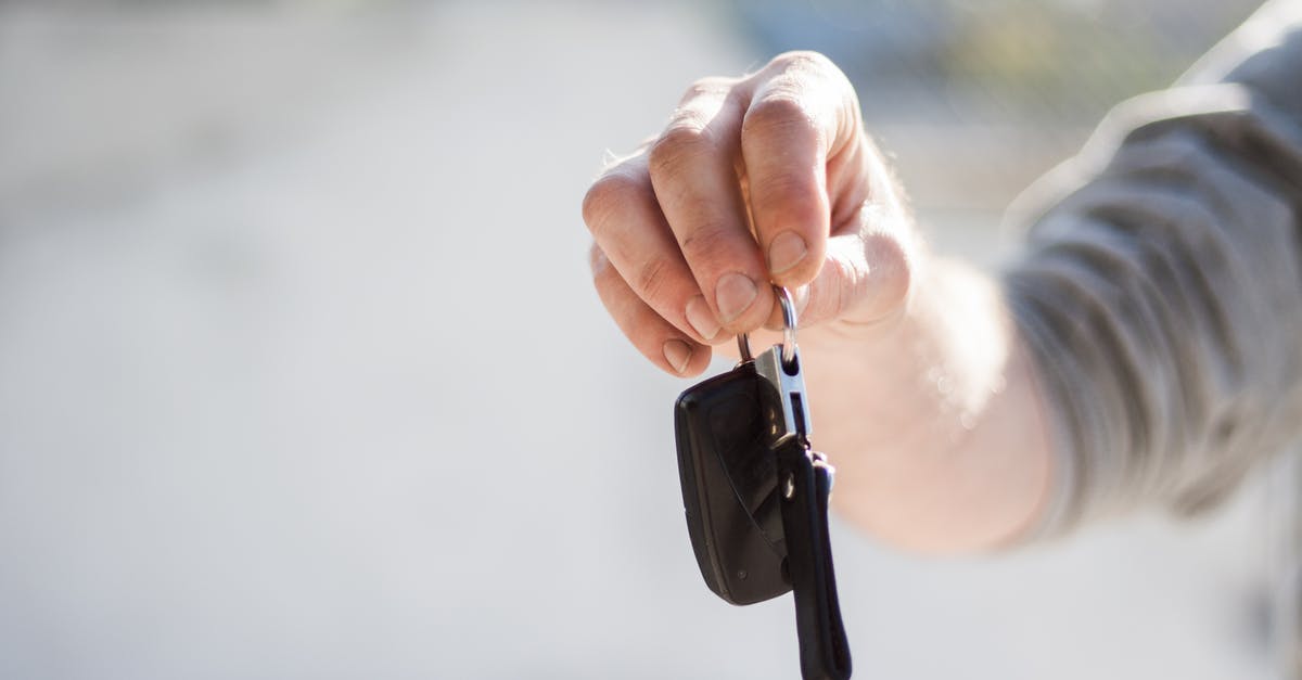 Why do rental car companies hand you two keys wired together? - Person in Grey Shirt Handing Keys Why do rental car companies hand you two keys wired together? - Person in Grey Shirt Handing Keys