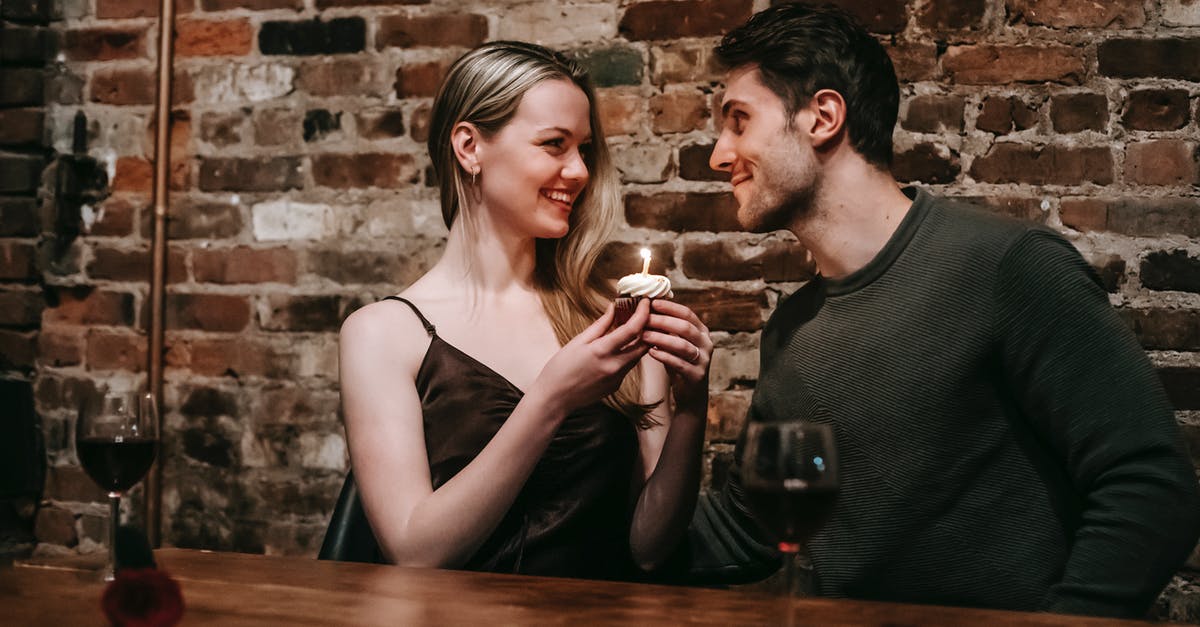 Why do restaurants and cafes in Ukraine make a transaction on each food separately? - Side view of loving couple sitting near brick wall at wooden table with cupcake with burning candle looking at each other while celebrating anniversary in cafe Why do restaurants and cafes in Ukraine make a transaction on each food separately? - Side view of loving couple sitting near brick wall at wooden table with cupcake with burning candle looking at each other while celebrating anniversary in cafe
