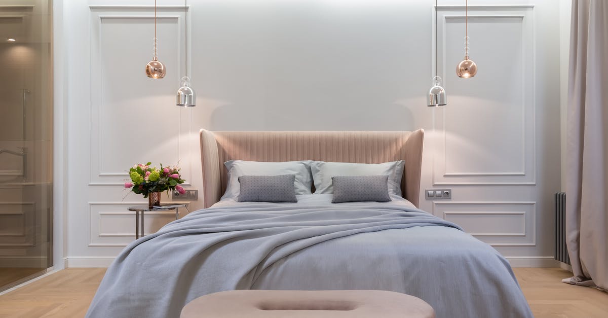 Why don't American hotels have ceiling lights? - Bedroom interior with bed near table under lamps Why don't American hotels have ceiling lights? - Bedroom interior with bed near table under lamps